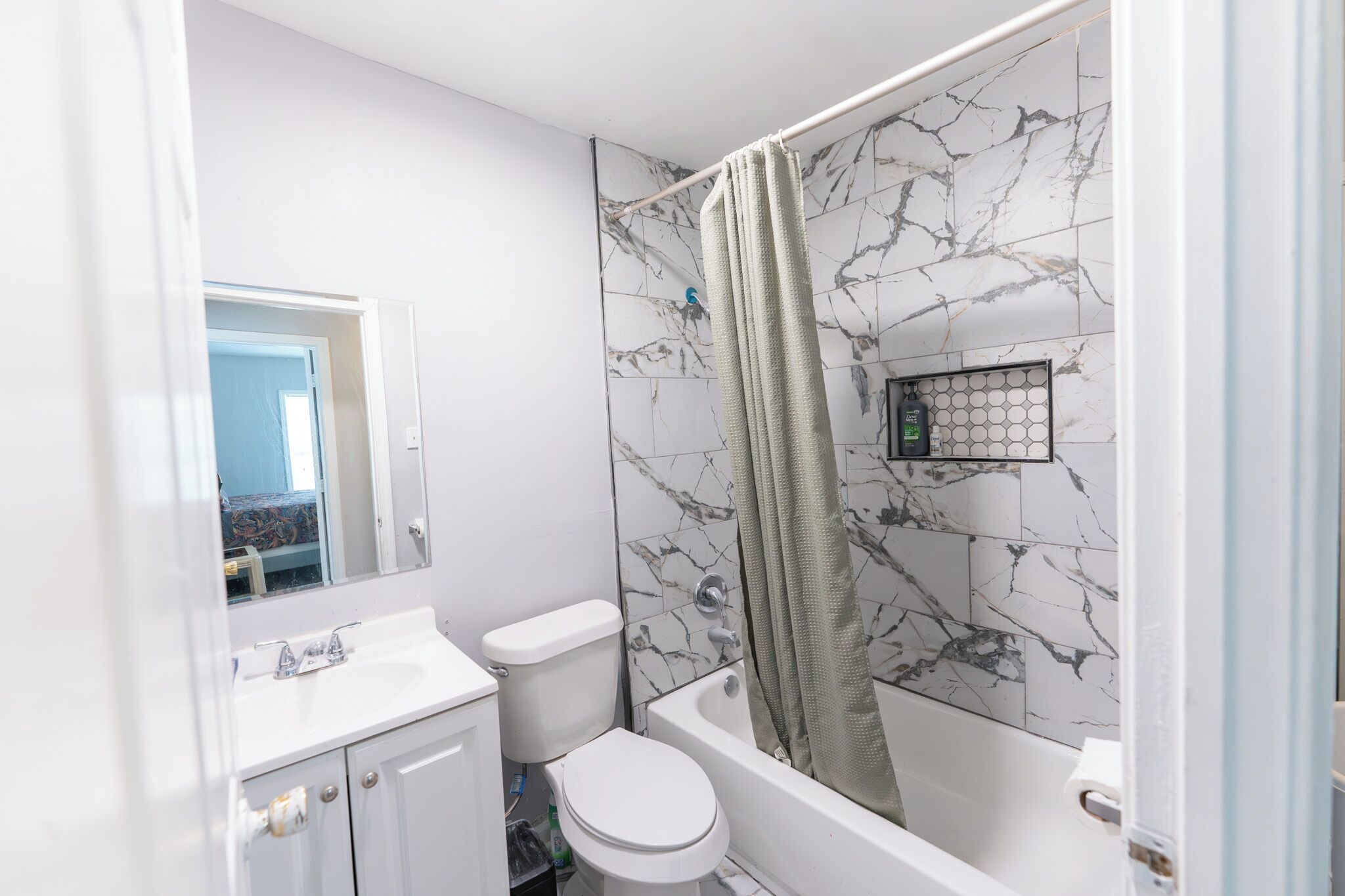 A bathroom with a white toilet, a sink, and a bathtub with a shower curtain.