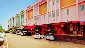 A multi-story hotel with a red awning and a sign that reads "Hotel." There are several cars parked in front, and the building has multiple balconies. - RS Hotel Desa Cemerlang Johor Jaya (Johor Bahru)