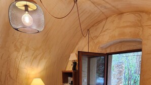 Een knusse woonkamer met een televisie, een houten tv-meubel en een salontafel met decoratieve objecten.