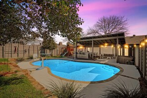 A backyard with a swimming pool, outdoor seating, and a covered patio area. - WorldCup/Pool/HotTub/Gaming/Pizzaoven/Transport (DeSoto)