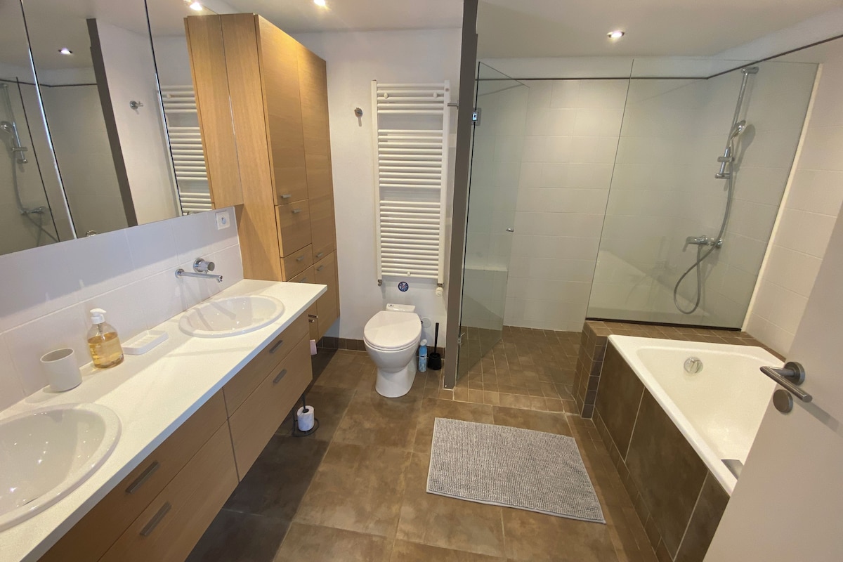 Ein modernes Badezimmer mit Waschbecken, Toilette, Dusche und Badewanne.