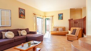 A spacious living room with a brown sofa, a smaller sofa, a coffee table, and a staircase. - Modern villa with BBQ and heatable pool (Albufeira)