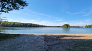 Ein Strand mit sandigem Ufer und einem ruhigen See.