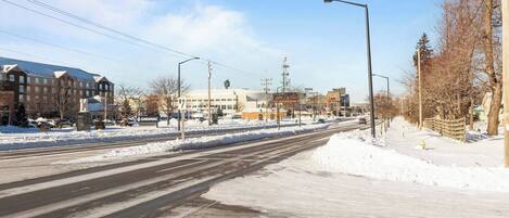 A snow-covered street with buildings, including a hotel with a sign that reads "Saranac."