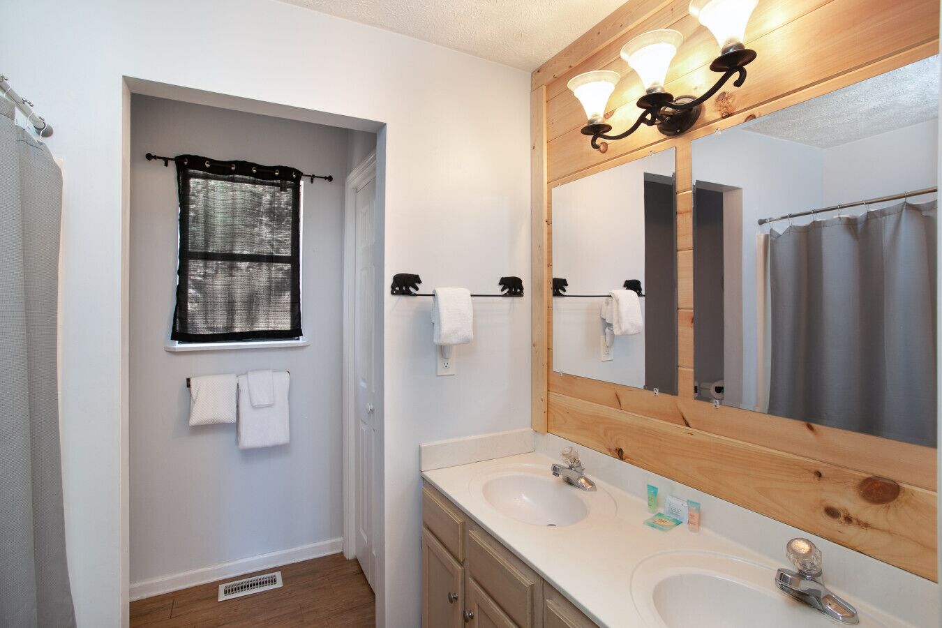 A bathroom with two sinks, a large mirror, and a shower curtain.