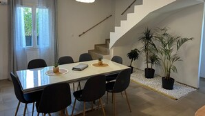 A dining area with a table, chairs, and a staircase.