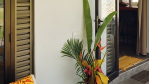 Un espacio moderno con un sofá, un letrero decorativo, una planta y una cesta de mimbre.
