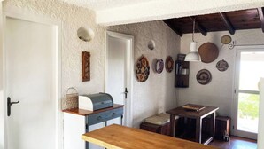 Eine kleine Küche mit einer Holzarbeitsplatte, einem eingebauten Backofen und einer rustikalen Decke.