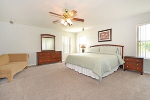 A bedroom with a bed, dresser, nightstand, and a ceiling fan. - Spacious villa with private pool, hot tub and games room (Davenport)