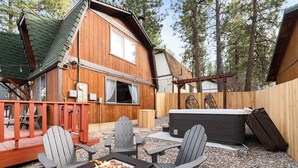 Een houten vakantiehuis met een terras, zitplaatsen buiten en een jacuzzi.