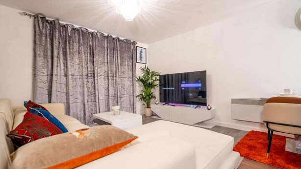 A modern living room with a white sofa, a coffee table, and a TV on a stand. - Apartmentsleeps4-citystay-view Over River Irwell (Salford)
