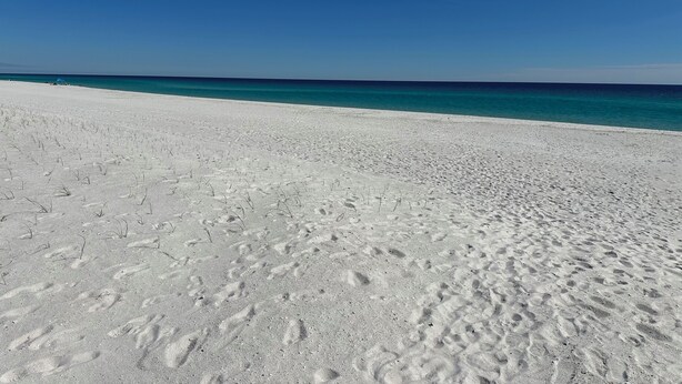 A wide sandy beach with footprints leading to the water. - The Retreat at Sunset Harbor (Navarre)