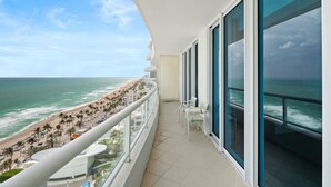 A balcony with a view of a beach and ocean.
