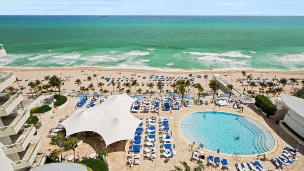 A resort with a pool, beach, and ocean view.