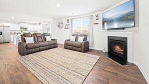 A modern living room with a fireplace, a large TV, and a sofa set. - Clemson University (6 min) - 1kMbps Internet - Easy Check In - Office Space (Pendleton)