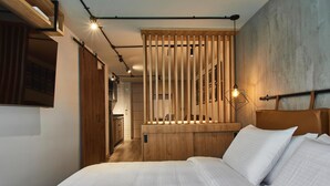A modern bedroom with a large bed, wooden slats, and a headboard.