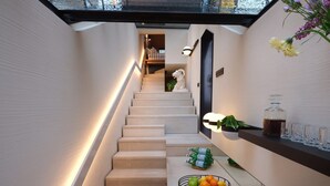 Ein modernes Interieur mit Treppe, Spüle, Obstschale und Wasserflasche.