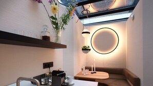Eine moderne Küche mit integriertem Spülbecken, einer Kaffeemaschine und einem runden Tisch mit Kerze.