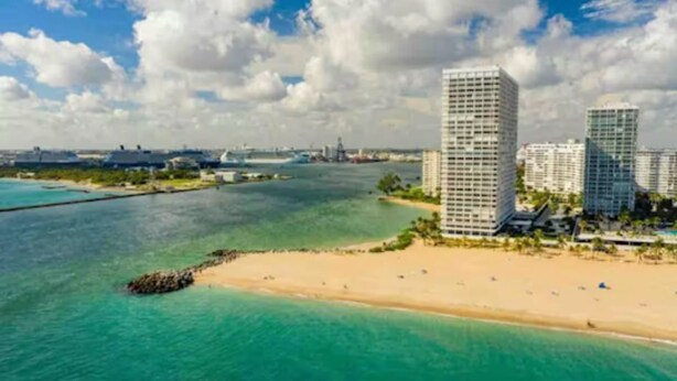 A coastal area with high-rise buildings, a beach, and a clear sky. - Coastal Luxury - 5 min to beach (Fort Lauderdale)