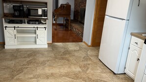 A kitchen with a microwave, coffee maker, and a refrigerator.
