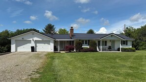 A single-story house with a garage, a covered porch, and a well-maintained lawn.