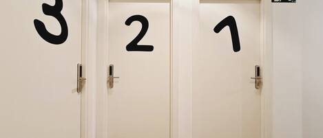 A hallway with three doors, each marked with a number.