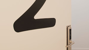A wall with a large black number '2' and a modern door with a keypad lock. - Bilbao ROOMS Etxebarria (Bilbao)