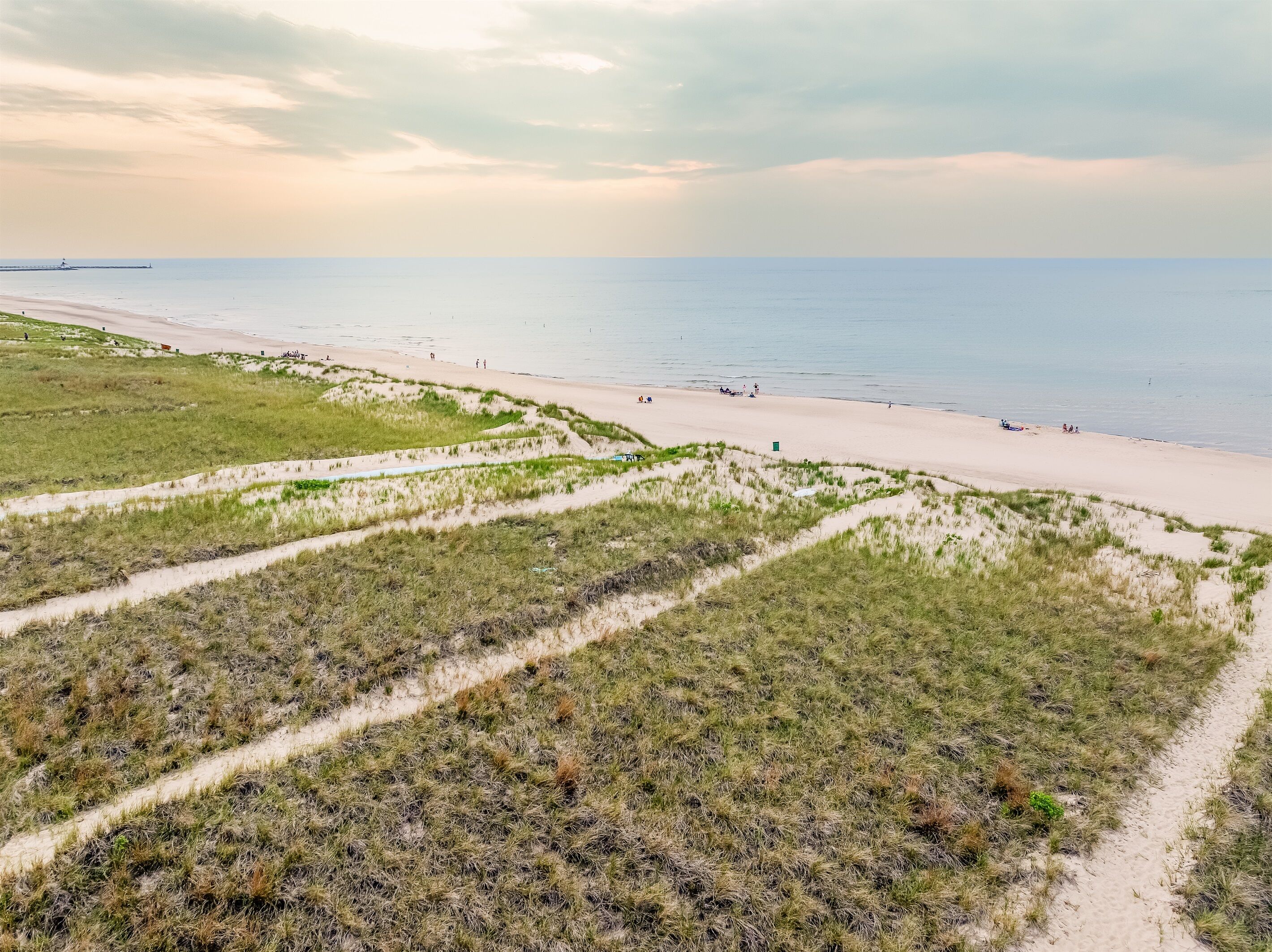Une plage avec des dunes de sable et une vue dégagée sur l’océan.