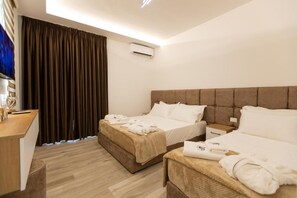 A hotel room with two beds, a desk, and a large window with curtains. - Zani's Villa (Vlorë)