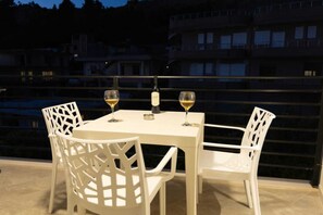 A terrace with a table and chairs, two glasses of wine, and a bottle on the table. - Zani's Villa (Vlorë)