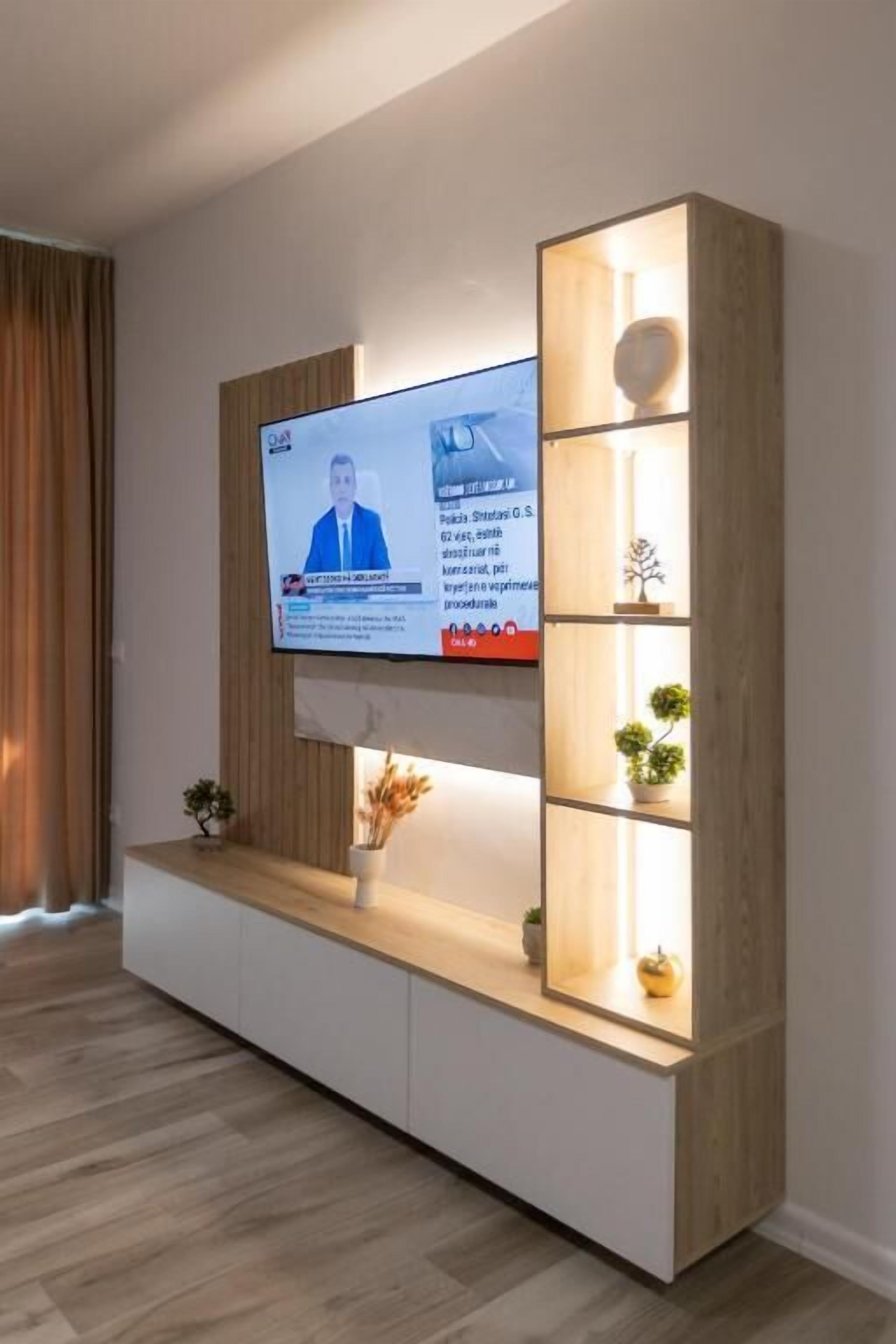 A modern living room with a flat-screen TV mounted on a wooden wall unit.