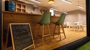Ein Café mit einer Kreidetafel, die kostenlosen Kaffee, Grillmöglichkeiten und einen Kinderspielplatz anbietet.