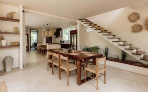 A modern kitchen with a dining area, a staircase, and a view of the outdoors. - Casa Zara Tulum Jungle Villa Sleeps 8 Beach Club (Tulum)