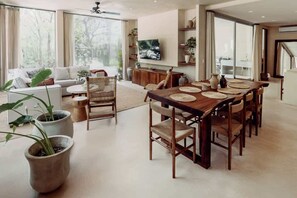 A spacious living area with a dining table, sofas, and a TV. - Casa Zara Tulum Jungle Villa Sleeps 8 Beach Club (Tulum)