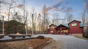 Eine Lodge mit Schotterbefestigung, Holzbanken und einer Feuerstelle.