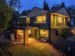 A two-story house with a balcony, a hot tub, and a covered patio area.