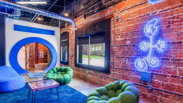 A modern interior with exposed brick walls, a neon sign, and comfortable seating areas. - b3 Room4: Begin King Suite (Sparta)