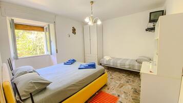 Une chambre à coucher avec un lit, une chaise, une armoire et un téléviseur.