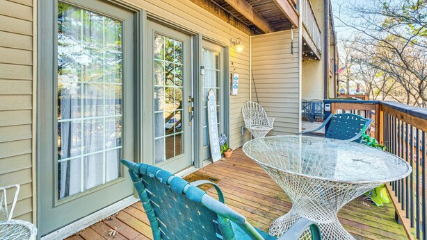 A wooden deck with a glass table and chairs, a welcome sign, and a covered area with chairs and a table. - 4 Mi to Greers Ferry Lake: Condo w/ Deck & Balcony (Fairfield Bay)