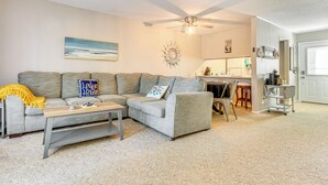 A living room with a grey sectional sofa, a wooden coffee table, and a ceiling fan. - 4 Mi to Greers Ferry Lake: Condo w/ Deck & Balcony (Fairfield Bay)