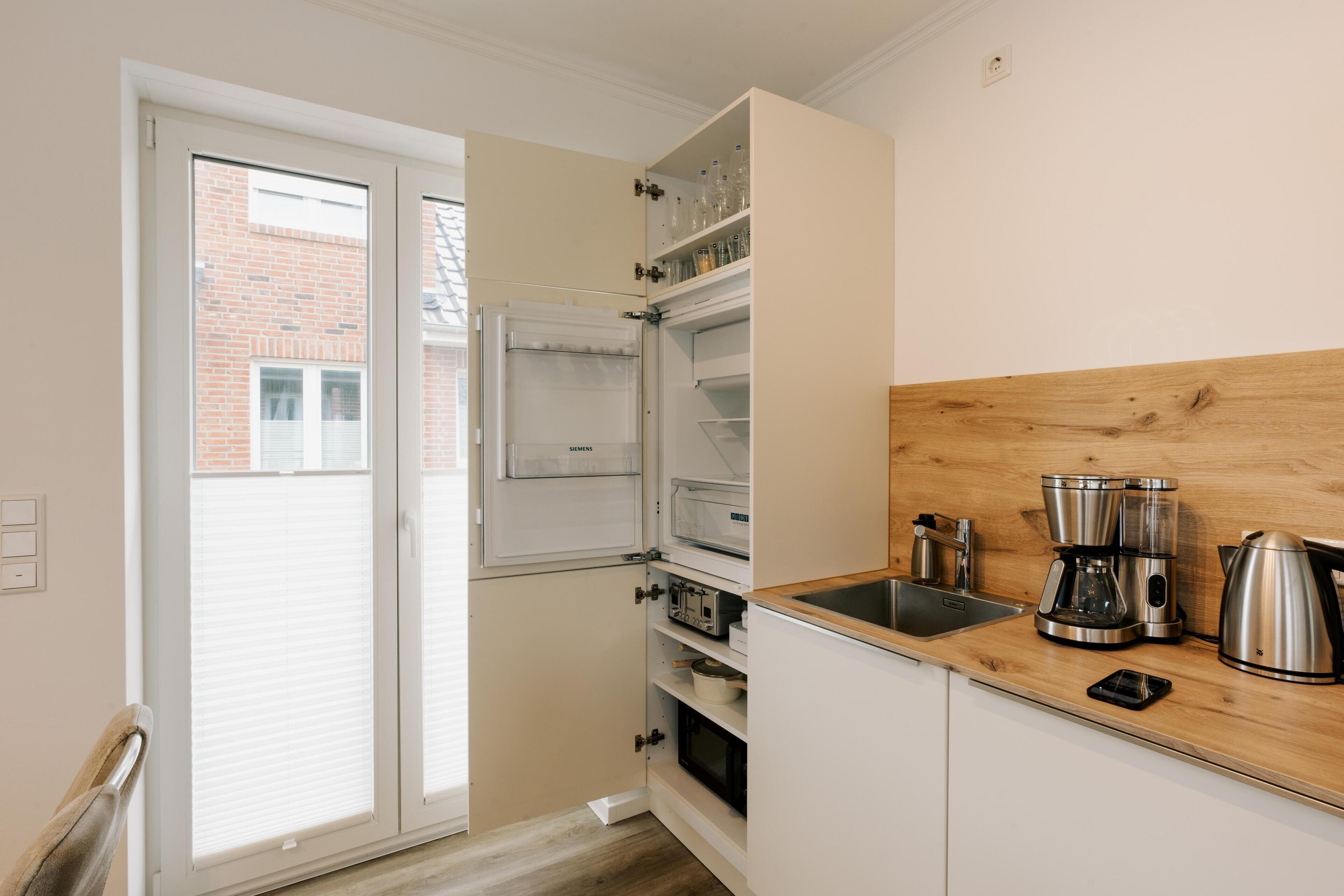 Een koffiezetapparaat/waterkoker, een koelkast, een magnetron, een oven