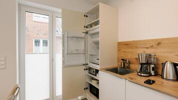 Een koffiezetapparaat/waterkoker, een koelkast, een magnetron, een oven