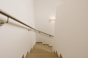 En trappa med ett metallräcke och beige trappsteg.