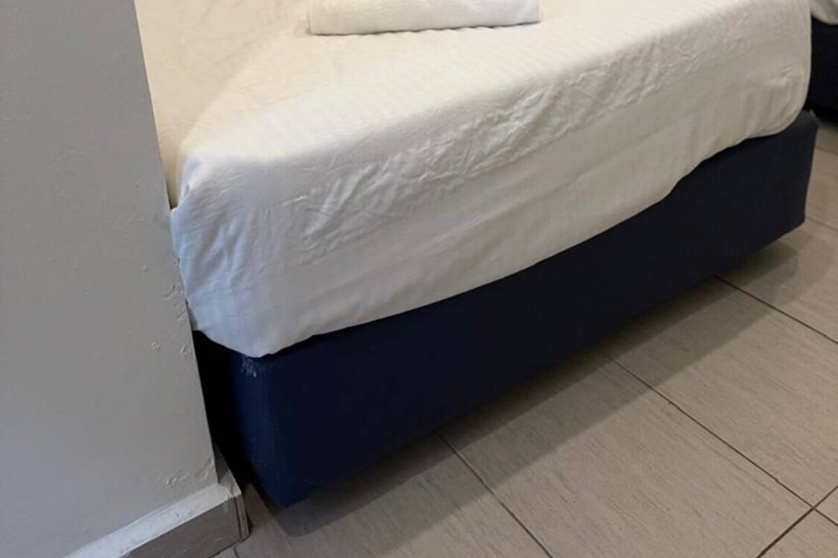 A hotel room with two beds, each with a wooden headboard and white bedding.