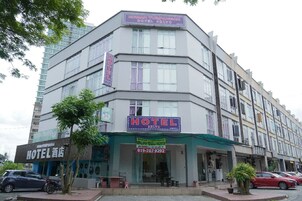 Un hotel de varios pisos con un llamativo letrero 'HOTEL' en la fachada.