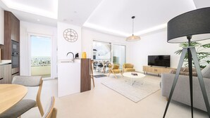 Un salon moderne comprenant un coin repas, une cuisine et un balcon.
