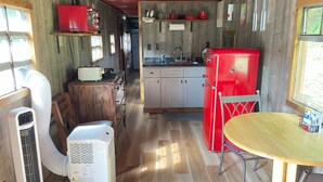 Una cocina compacta con un refrigerador rojo, un lavamanos y armarios de madera.