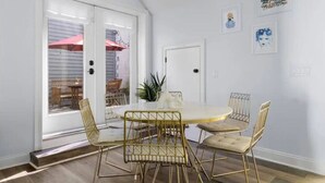 A dining area with a round table, four chairs, and a potted plant. - 4 Bedroom - 4 Blocks to King St. with Parking (Charleston)