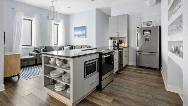 A modern kitchen with a central island, built-in oven, and refrigerator. - 4 Bedroom - 4 Blocks to King St. with Parking (Charleston)
