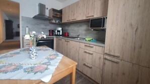Une cuisine moderne avec des meubles en bois, un four à micro-ondes et une machine à café.
